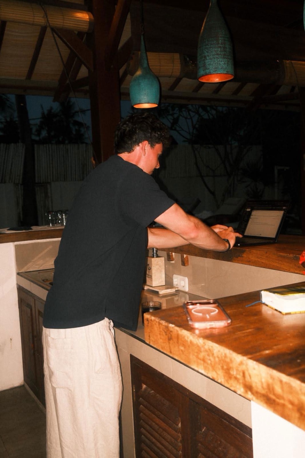 Liam working on his laptop at a wooden counter.